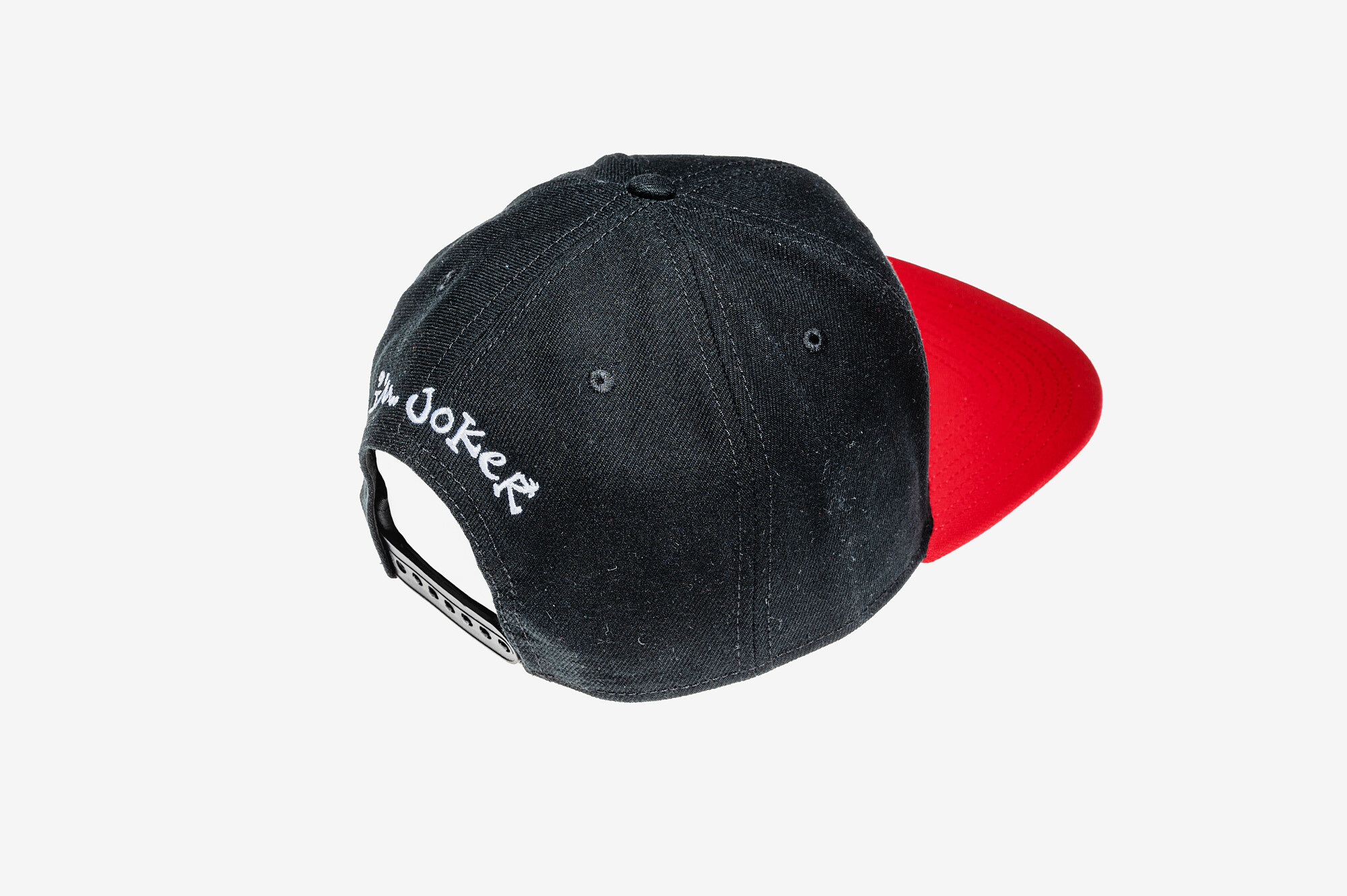 Černo-červená snapback kšiltovka I'M..JoKeR s bílou 3D výšivkou čepičky 3 Detail zadní části černé kšiltovky I'M..JoKeR s bílou výšivkou a nastavitelnou patentkou